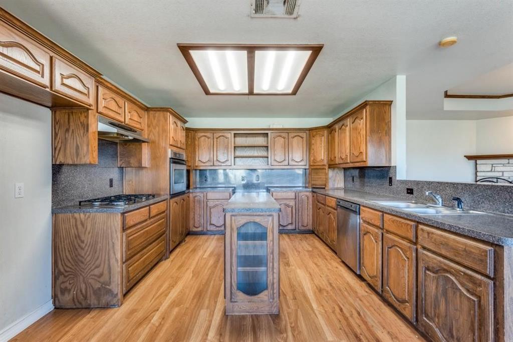 2072 Marshall Road Waxahachie, TX 75167 - Photo 10 of 14 a kitchen with stainless steel appliances granite countertop wooden cabinets a stove a sink and a wooden floors