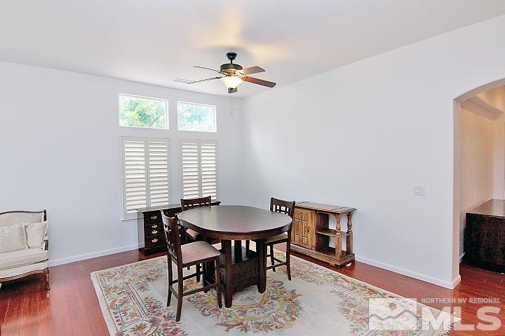 450 Manciano Way Reno, NV 89521 - Photo 14 of 39 a dining room with wooden floor a chandelier a wooden table and chairs