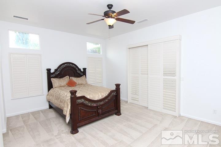 450 Manciano Way Reno, NV 89521 - Photo 19 of 39 a bedroom with a bed and a chandelier