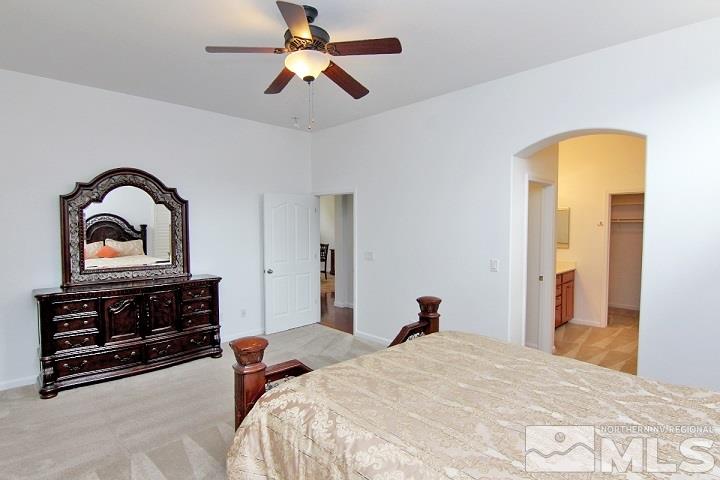 450 Manciano Way Reno, NV 89521 - Photo 21 of 39 a bedroom with a bed and a chandelier