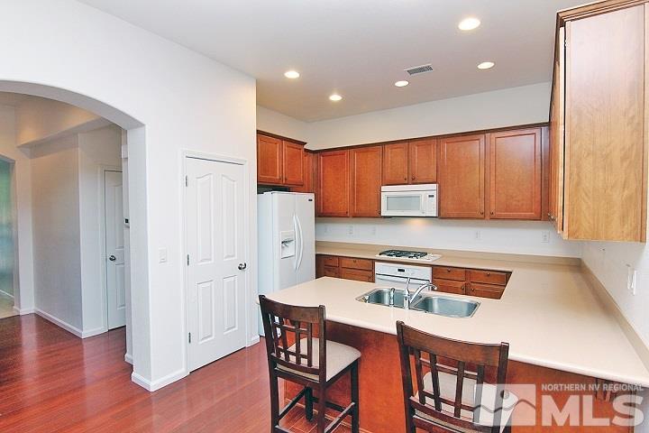 450 Manciano Way Reno, NV 89521 - Photo 8 of 39 a kitchen with stainless steel appliances granite countertop a refrigerator and a stove top oven