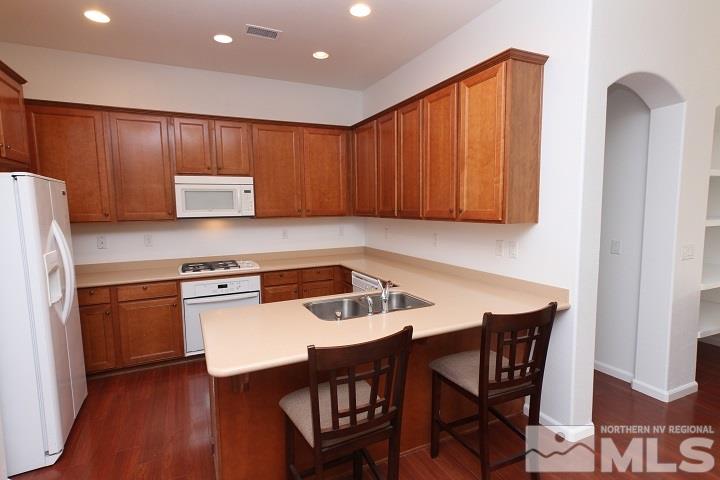 450 Manciano Way Reno, NV 89521 - Photo 10 of 39 a kitchen with stainless steel appliances granite countertop a table chairs sink and cabinets