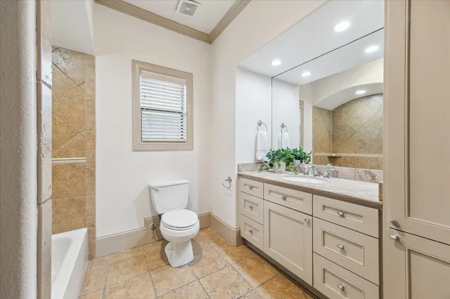 a spacious bathroom with a granite countertop sink a toilet and a mirror