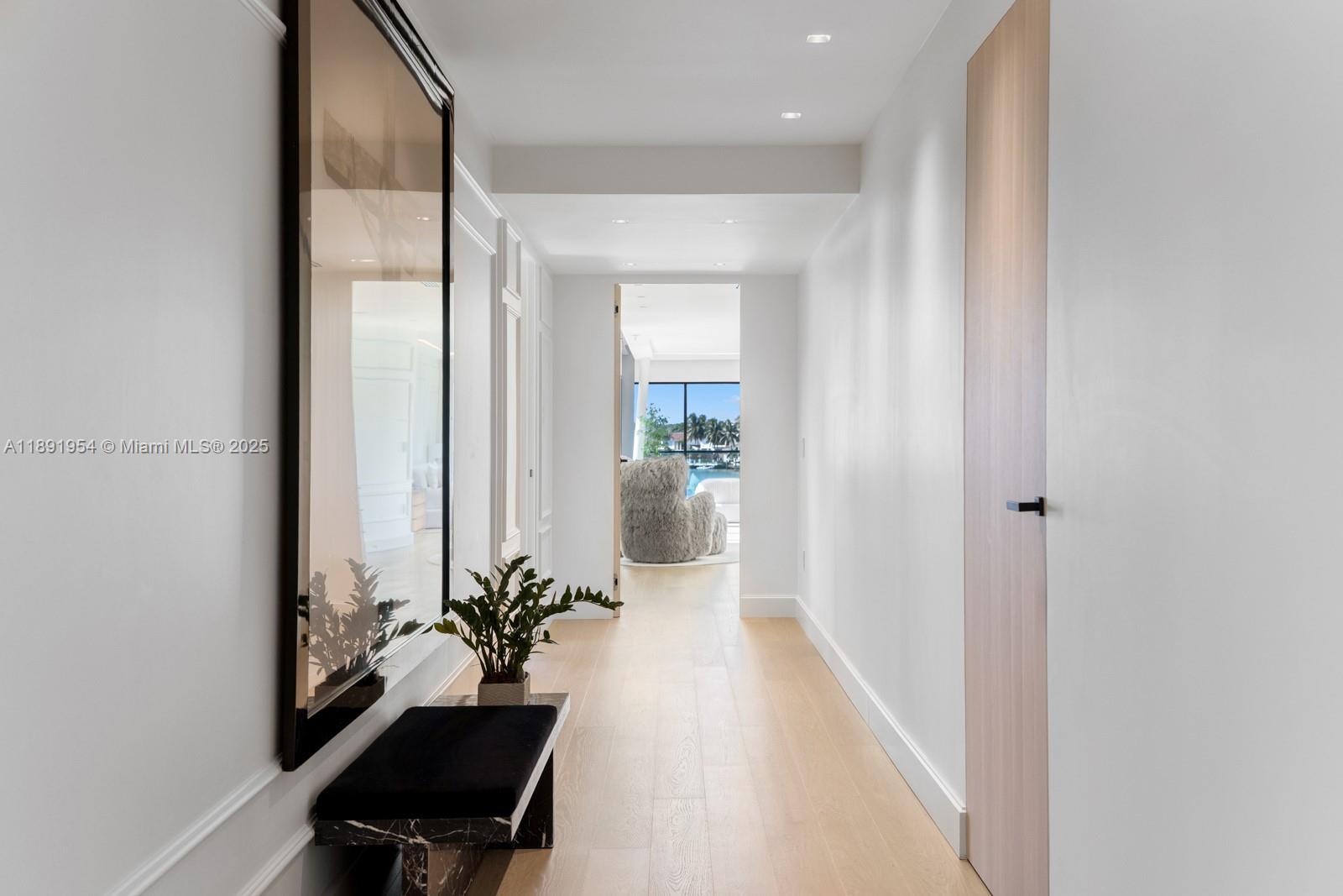 1155-1165 North Biscayne Point Road Miami Beach, FL 33141 - Photo 18 of 35 a hallway with a potted plant on the table and a chair