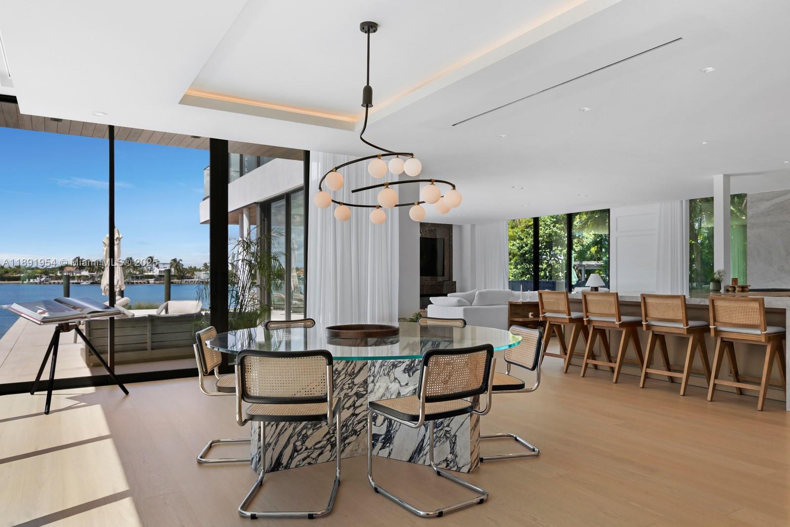 1155-1165 North Biscayne Point Road Miami Beach, FL 33141 - Photo 7 of 35 a dining room with furniture a chandelier and wooden floor