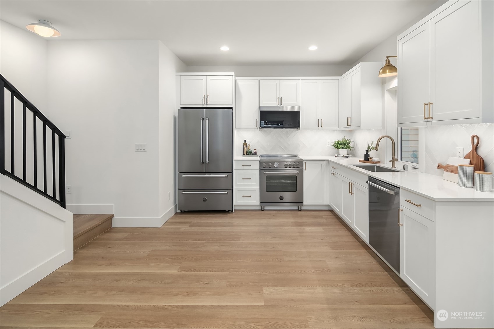 3011 Northwest 66th Street Seattle, WA 98117 - Photo 4 of 15 a kitchen with stainless steel appliances a sink cabinets and a refrigerator