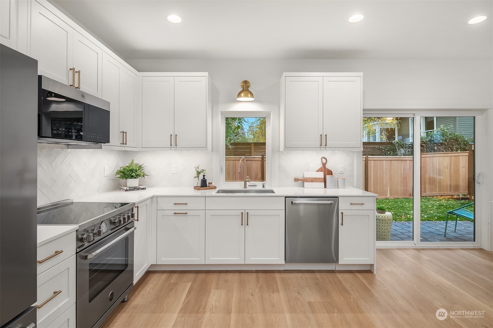 3011 Northwest 66th Street Seattle, WA 98117 - Photo 5 of 15 a kitchen with stainless steel appliances a stove sink and cabinets
