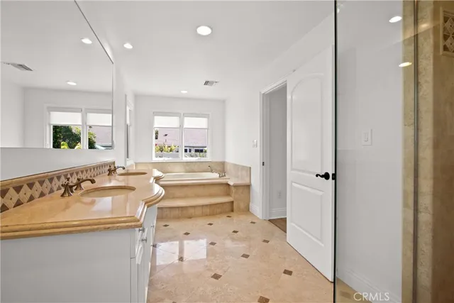 a bathroom with a tub sink and mirror