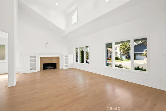 a view of an empty room with a fireplace and a window