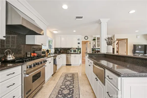 a large kitchen with granite countertop lots of counter space and a sink