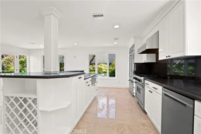 a large white kitchen with a stove a sink and a refrigerator