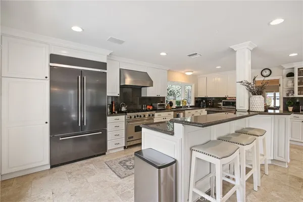 a kitchen with white cabinets and stainless steel appliances