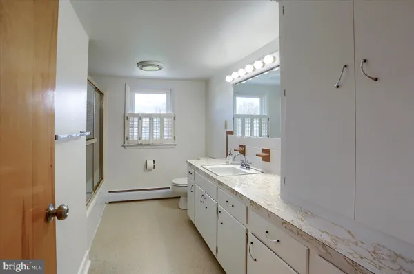 a spacious bathroom with a double vanity sink a mirror and a shower