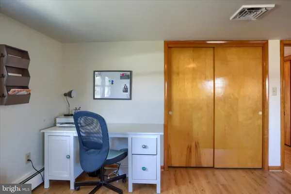 a view of a workspace with furniture and wooden floor