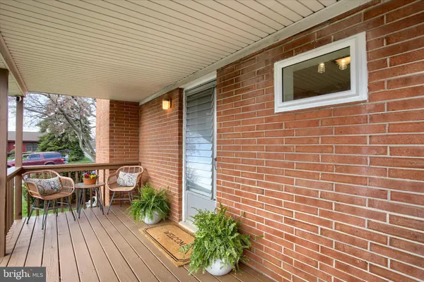 a view of a patio with table and chairs potted plants with wooden floor and floor to ceiling window