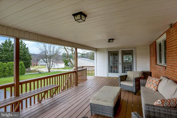 a view of a porch with furniture and wooden floor