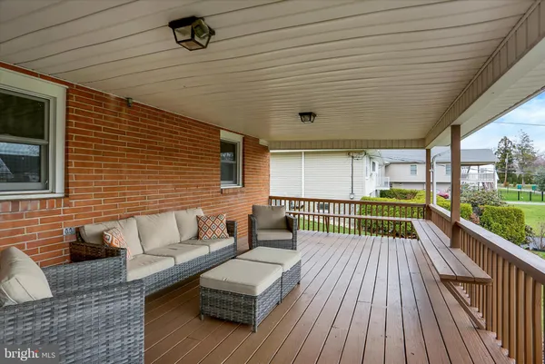 a view of a patio with couches chairs floor to ceiling window with wooden floor