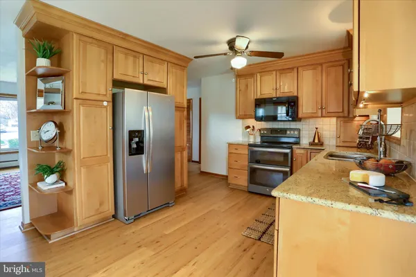 a kitchen with stainless steel appliances granite countertop a refrigerator a stove and a sink