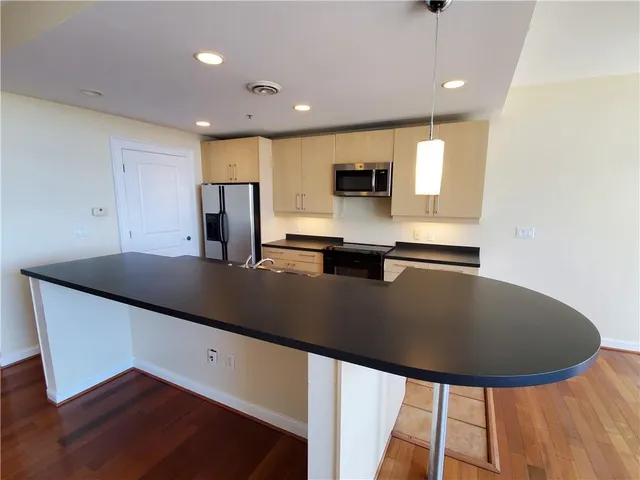 a kitchen with stainless steel appliances granite countertop a sink a stove top oven a counter space and cabinets