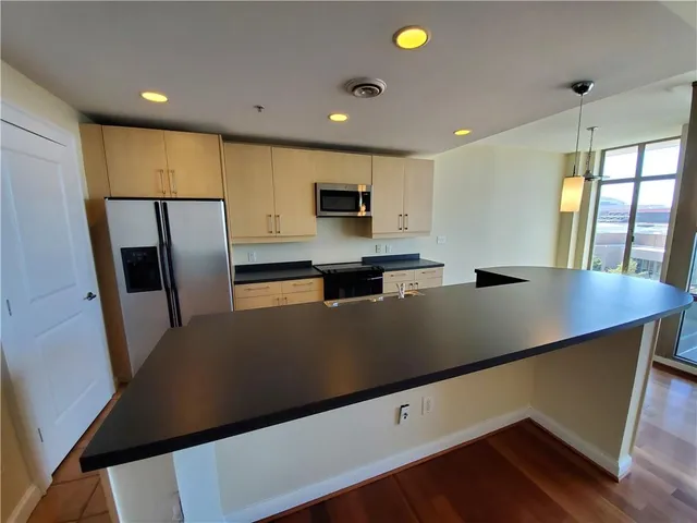 a view of kitchen with stainless steel appliances a refrigerator and a stove top oven