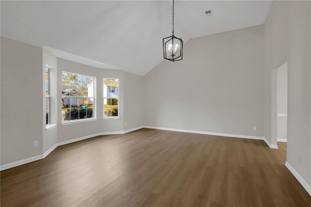 6566 Shaffers Way Lithonia, GA 30058 - Photo 3 of 31 an empty room with wooden floor and windows