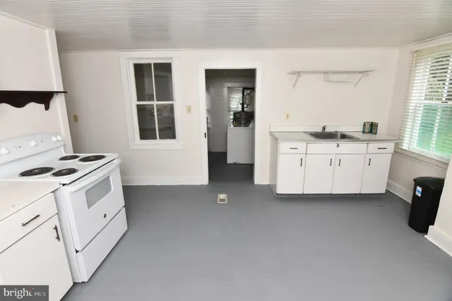 a kitchen with white cabinets and white appliances