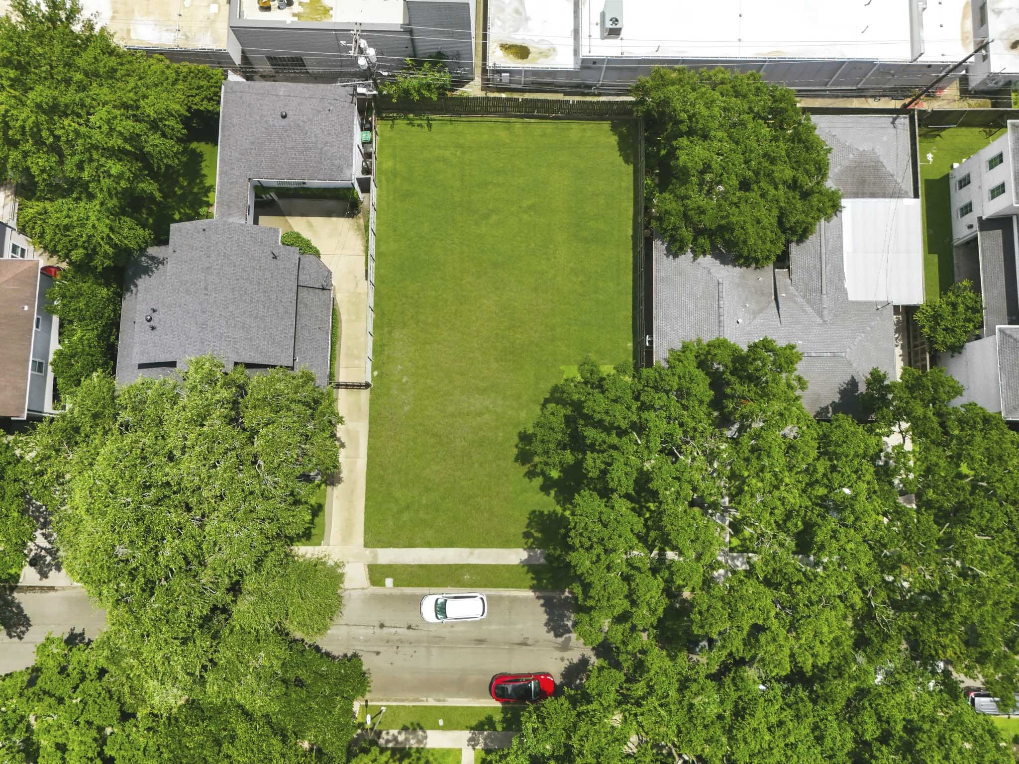 4227 Markham Street Houston, TX 77027 - Photo 5 of 7 This aerial photo shows a spacious, empty plot of land surrounded by residential homes. The lot is bordered by trees, providing a sense of privacy. It's situated on a quiet street with easy access to surrounding properties.