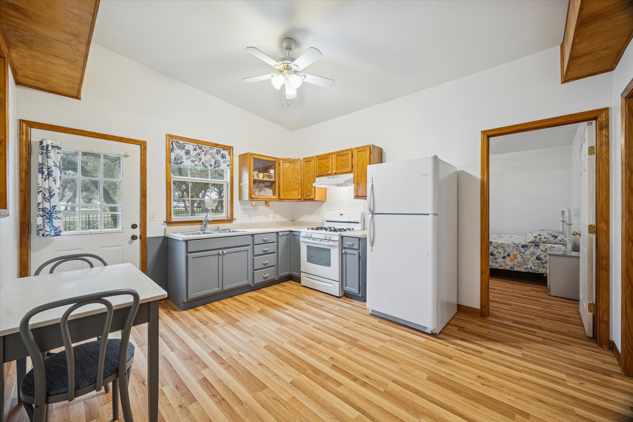 3502 1869th Ranch Liberty Hill, TX 78642 - Photo 11 of 20 Kitchen featuring gray cabinetry, white appliances, light countertops, light wood-type flooring, and ceiling fan