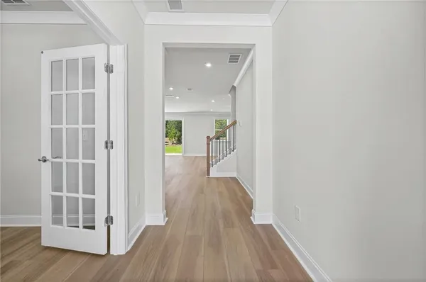 a view of a hallway with wooden floor and closet