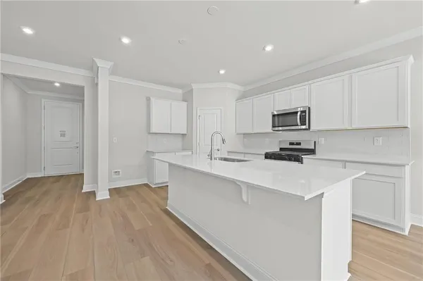 a kitchen with a sink a microwave a refrigerator and cabinets