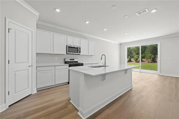 a kitchen with sink a microwave and cabinets