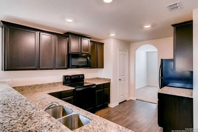 a kitchen with granite countertop wooden cabinets and stainless steel appliances