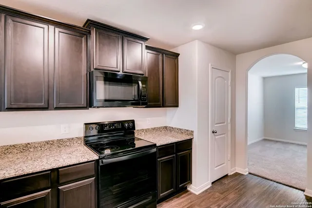 a kitchen with stainless steel appliances granite countertop a stove and a microwave