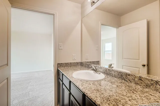 a bathroom with a granite countertop sink and a mirror