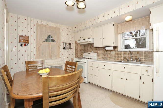 22-09 Arcadia Road Fair Lawn, NJ 07410 - Photo 4 of 28 a kitchen with a table chairs sink and cabinets