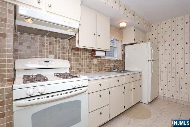 22-09 Arcadia Road Fair Lawn, NJ 07410 - Photo 5 of 28 a kitchen with appliances cabinets and a counter top space