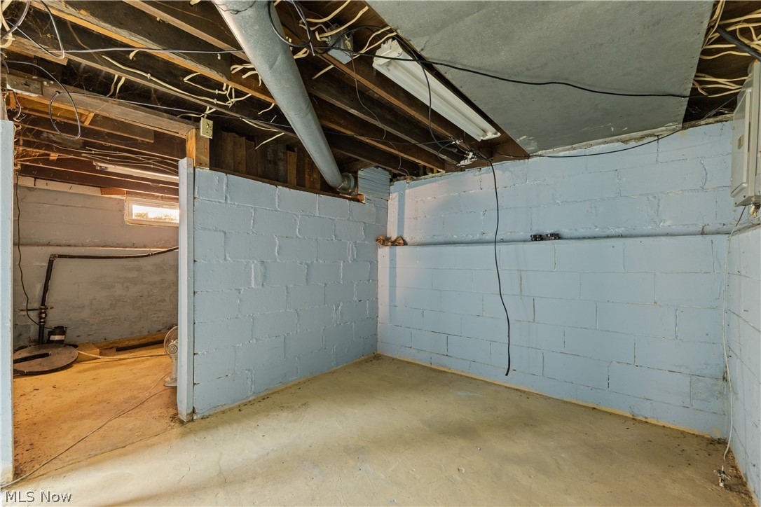 409 Edith Avenue Akron, OH 44312 - Photo 28 of 45 Unfinished basement featuring concrete block walls, exposed ceiling joists, and concrete flooring