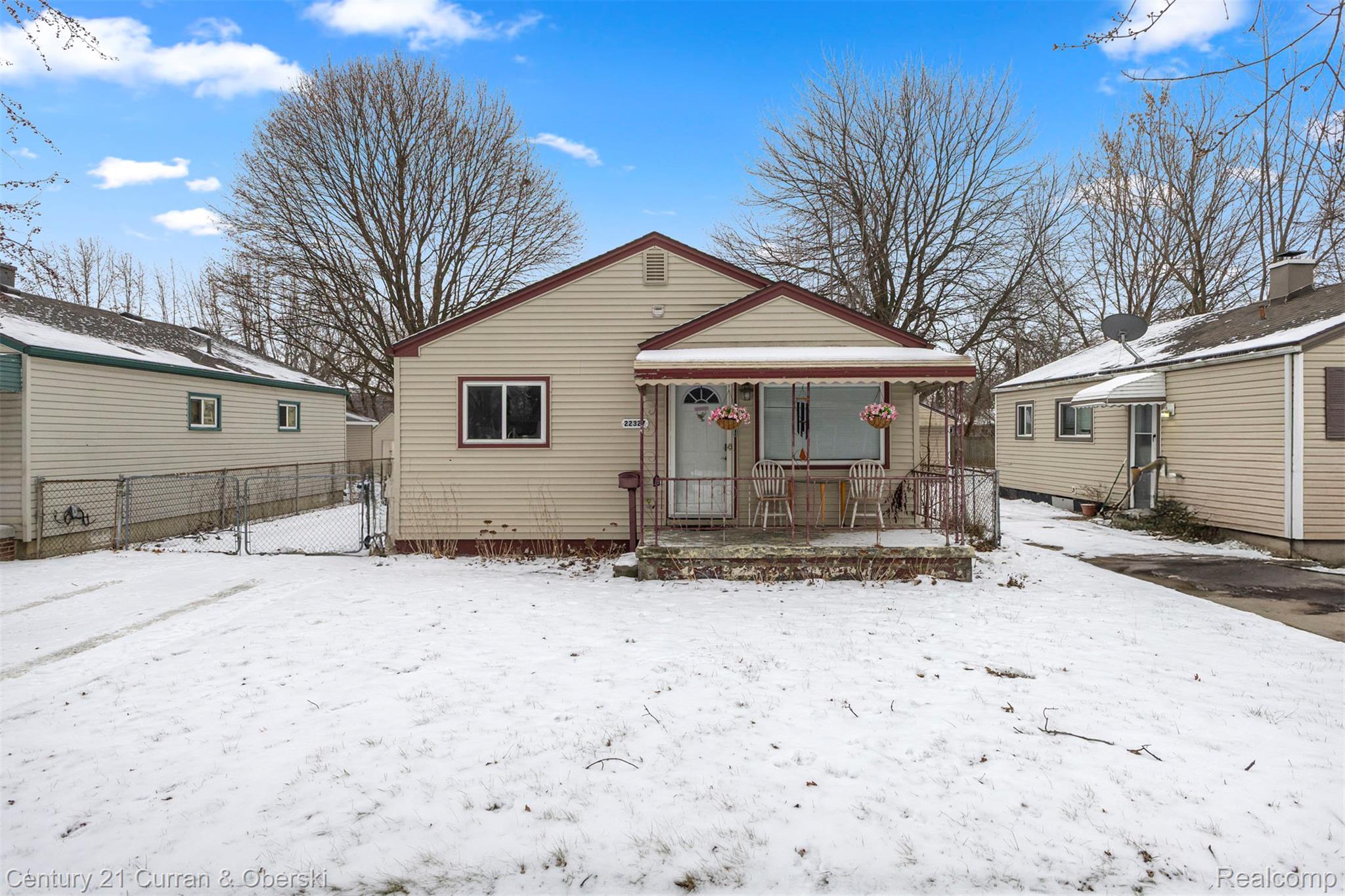 Snow covered rear of property with a gate
