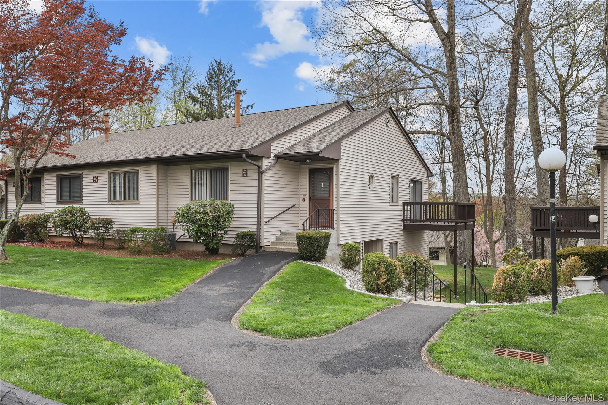 116 Village Road, Unit D Yorktown Heights, NY 10598 - Photo 2 of 32 a front view of a house with a yard and garage