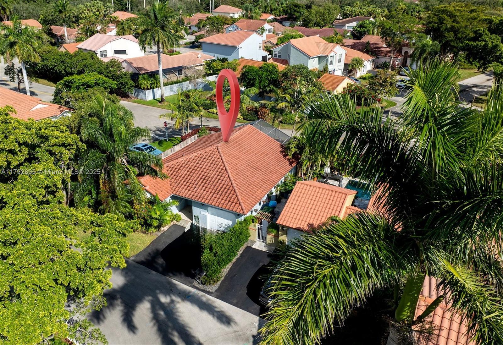 an aerial view of a house with yard and swimming pool