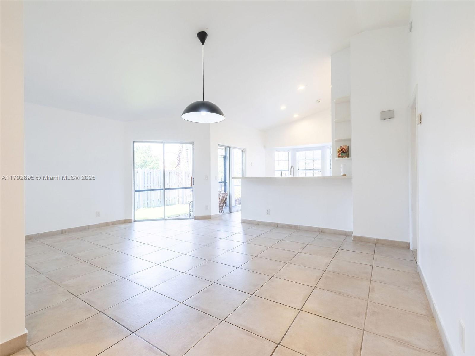 1225 Seagrape Circle Weston, FL 33326 - Photo 15 of 61 a view of an empty room and window and chandelier fan