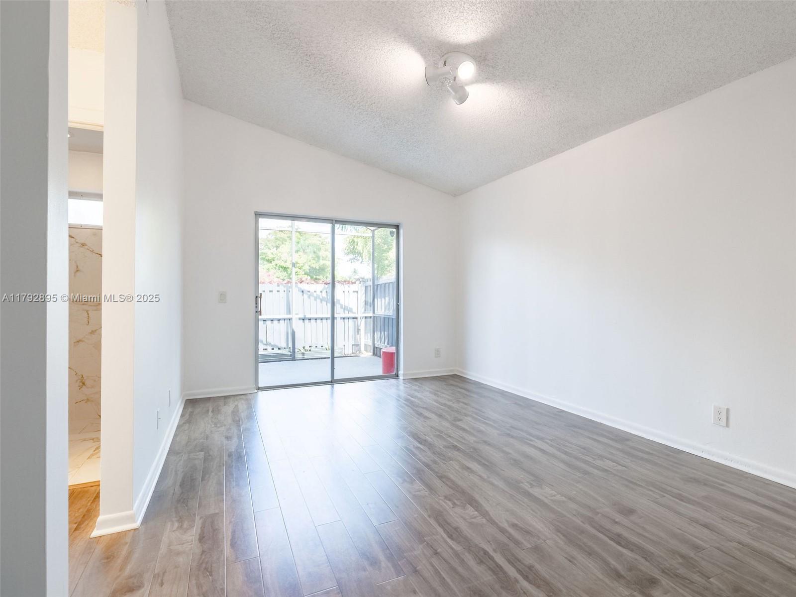 1225 Seagrape Circle Weston, FL 33326 - Photo 22 of 61 an empty room with wooden floor and windows
