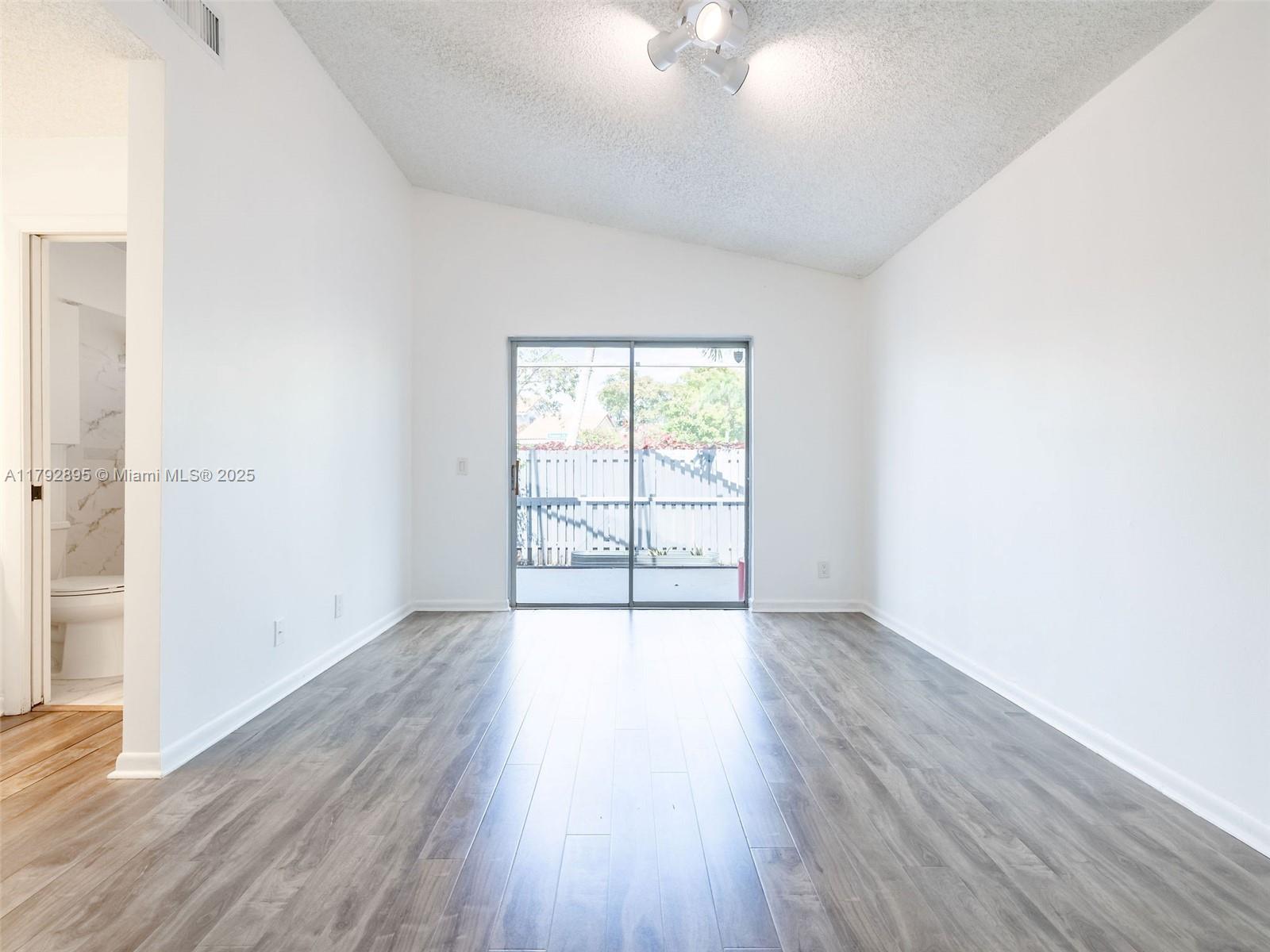 1225 Seagrape Circle Weston, FL 33326 - Photo 23 of 61 an empty room with wooden floor and windows