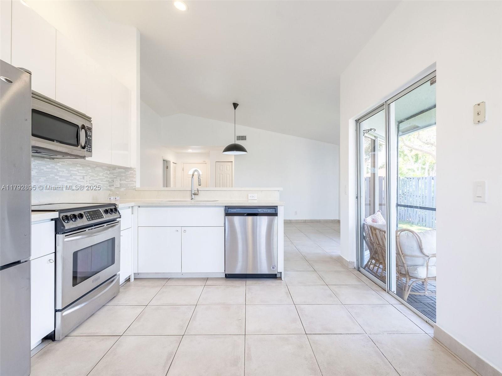 1225 Seagrape Circle Weston, FL 33326 - Photo 3 of 61 a kitchen with a stove a sink and a microwave