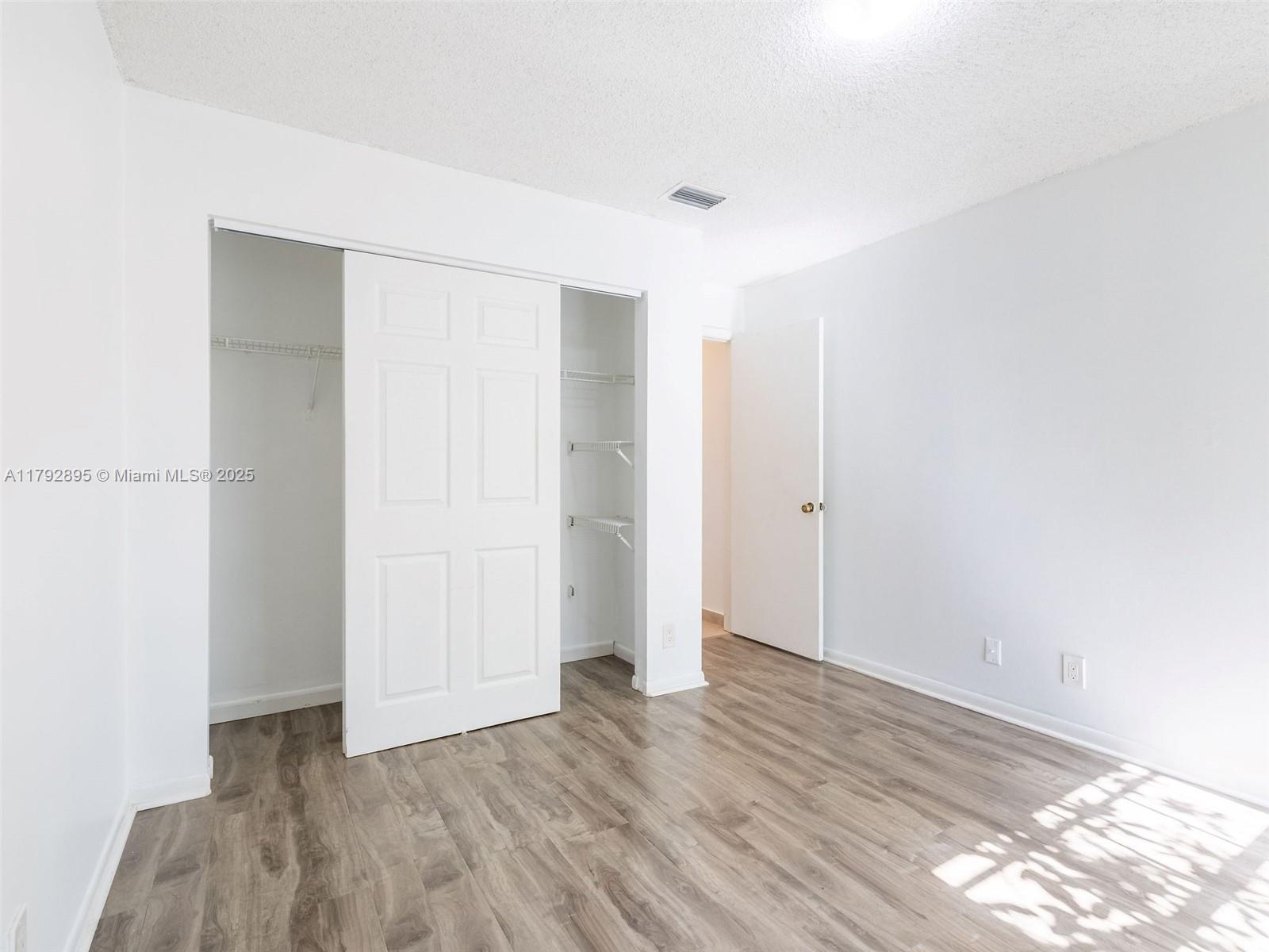 1225 Seagrape Circle Weston, FL 33326 - Photo 33 of 61 a view of an empty room with wooden floor