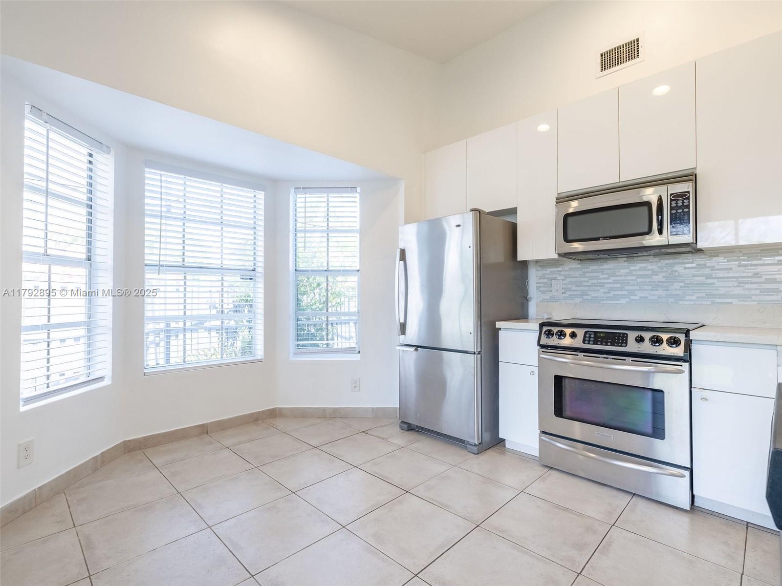 1225 Seagrape Circle Weston, FL 33326 - Photo 4 of 61 a kitchen with granite countertop a refrigerator and a stove top oven