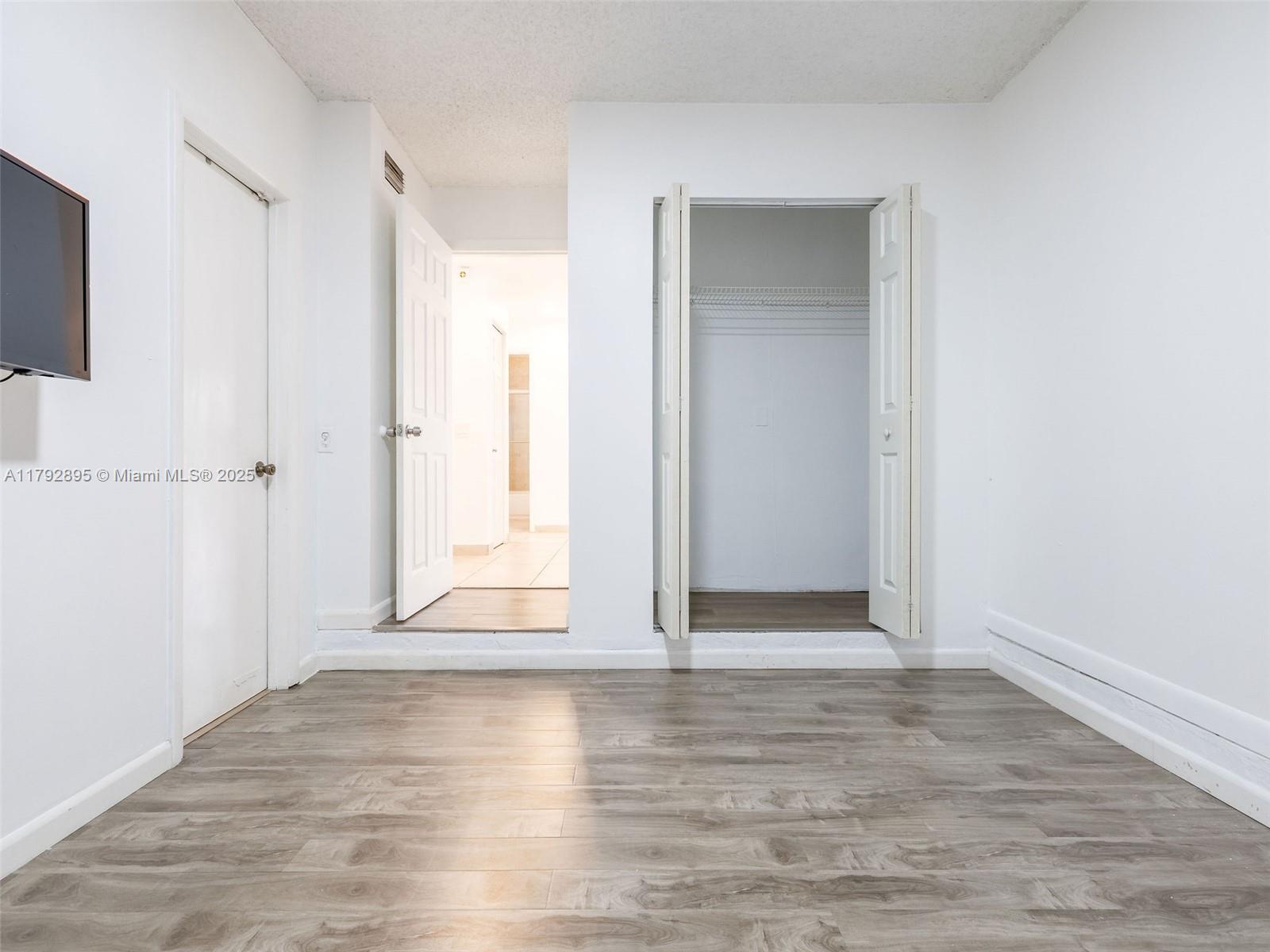 1225 Seagrape Circle Weston, FL 33326 - Photo 41 of 61 a view of an empty room with wooden floor and a window