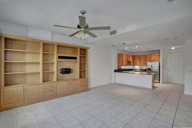 a large white kitchen with kitchen island a sink stainless steel appliances and cabinets