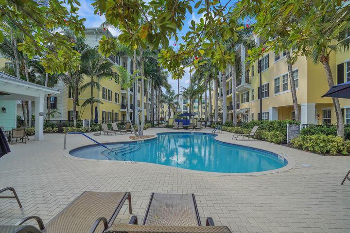 3120 East Latitude Circle, Unit 309 Delray Beach, FL 33483 - Photo 2 of 32 a swimming pool with outdoor seating and yard