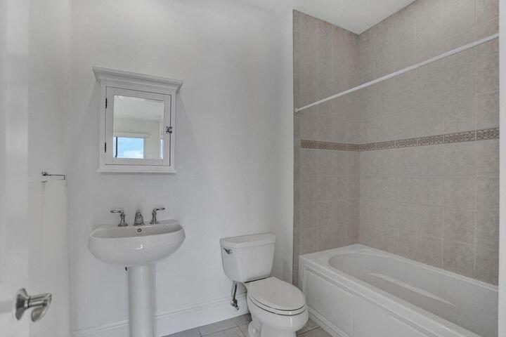 3120 East Latitude Circle, Unit 309 Delray Beach, FL 33483 - Photo 21 of 32 a bathroom with a sink toilet and shower